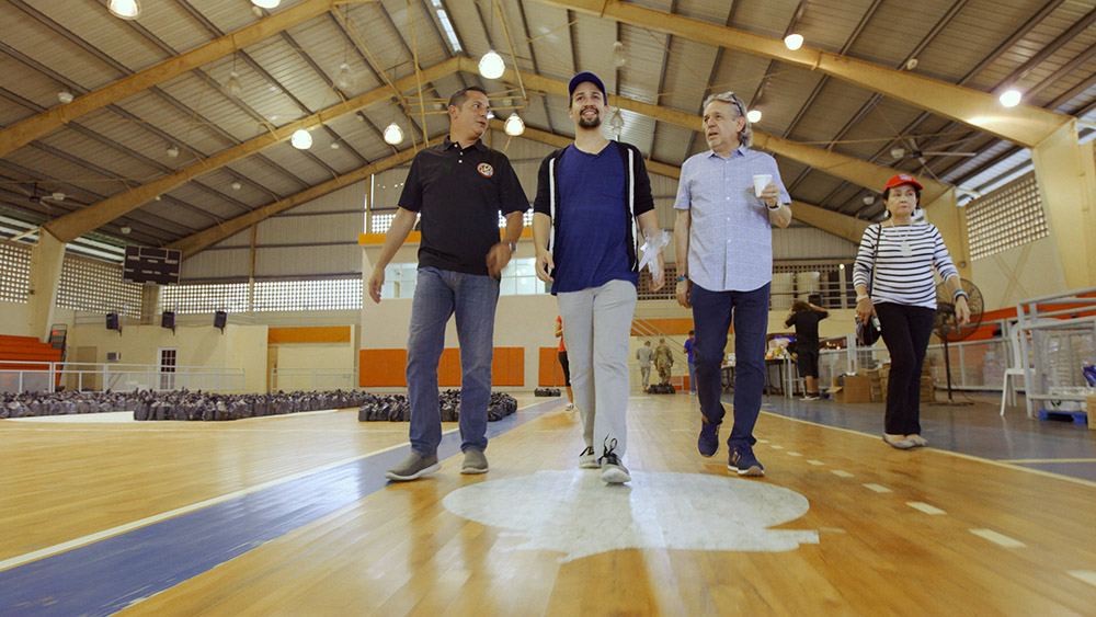 Lin-Manuel Miranda (center) with his father, Luis Miranda (right), and mother, Luz Towns-Miranda (far right), assisting with disaster relief efforts in Puerto Rico (Courtesy of HBO)