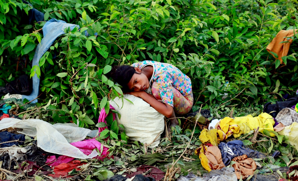 A Rohingya refugee girl rests after arriving Sept. 14 at a makeshift refugee camp in Cox's Bazar, Bangladesh. (CNS/Reuters/Danish Siddiqui)