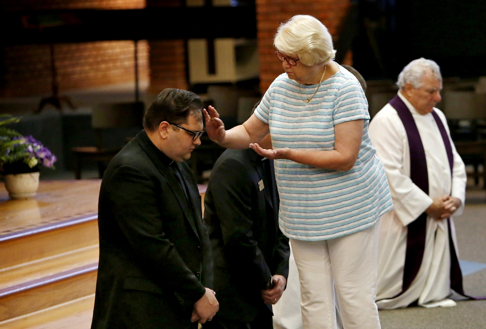 A woman administers ashes on the forehead of a priest during a prayer service for repentance and healing for clergy sexual abuse Aug. 22 at Our Lady of the Brook in Northbrook, Illinois. (CNS/Chicago Catholic/Karen Callaway)