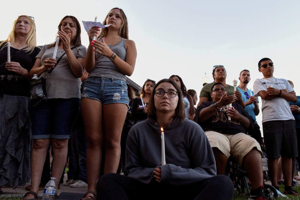 People attend a candlelight vigil outside Gilroy City Hall in California July 29, 2019, honoring those that died and were injured during a mass shooting at the Gilroy Garlic Festival a day earlier. The Diocese of San Jose held a bilingual prayer vigil Jul