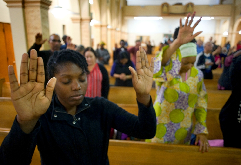 A young woman prays on the second evening of an African American Catholic revival celebration Feb. 6, 2018, at St. Rita's Catholic Church in San Diego. (CNS/David Maung)