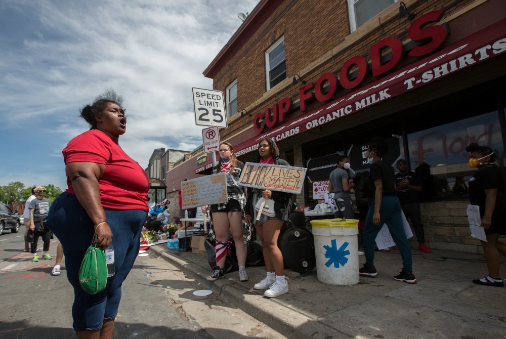 A woman in Minneapolis expresses her anger and frustration May 28 at the site where George Floyd was pinned down May 25 by a police officer. Floyd later died at a local hospital. (CNS/The Catholic Spirit/Dave Hrbacek)