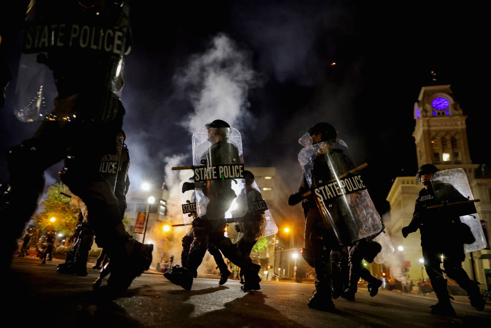 Police officers in Louisville, Kentucky, move past city hall Sept. 23 to clear protesters from a plaza ahead of a 9 p.m. curfew. (CNS/Reuters/Carlos Barria)