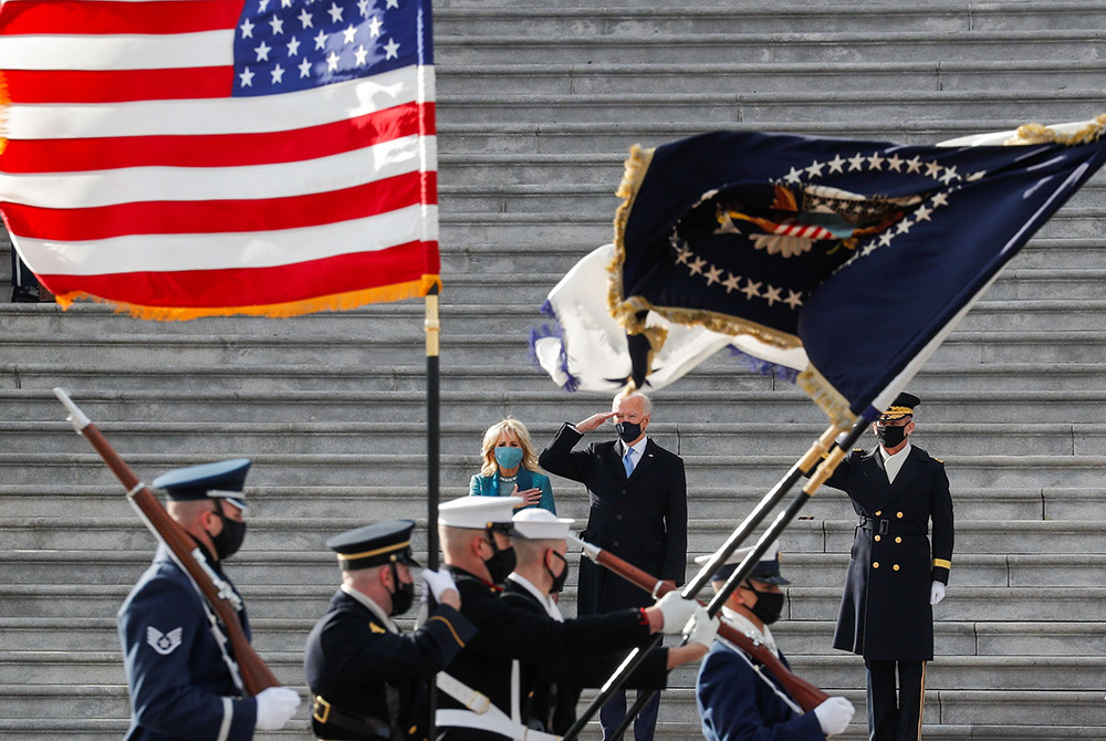 President Joe Biden and first lady Jill Biden review the readiness of military troops in a pass-in-review ceremony at the U.S. Capitol Jan. 20 in Washington. (CNS/Mike Segar, Reuters)