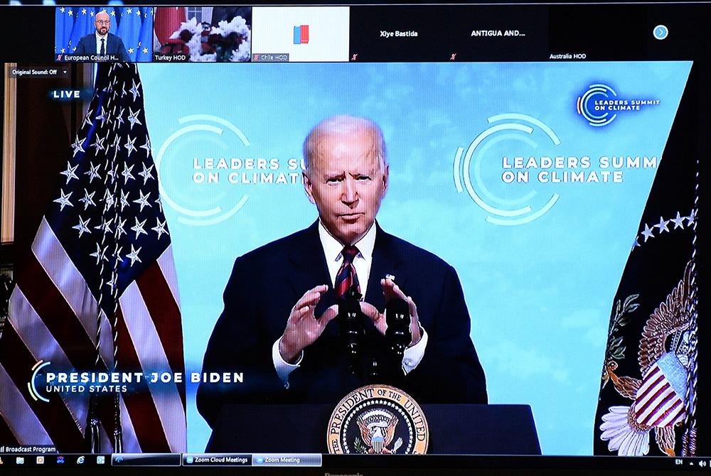 President Joe Biden is seen on a screen in Brussels, Belgium, April 22, 2021, as European Council President Charles Michel attends a virtual global climate summit. Biden committed the United States to cut greenhouse emissions in half by 2030. (CNS/Johanna