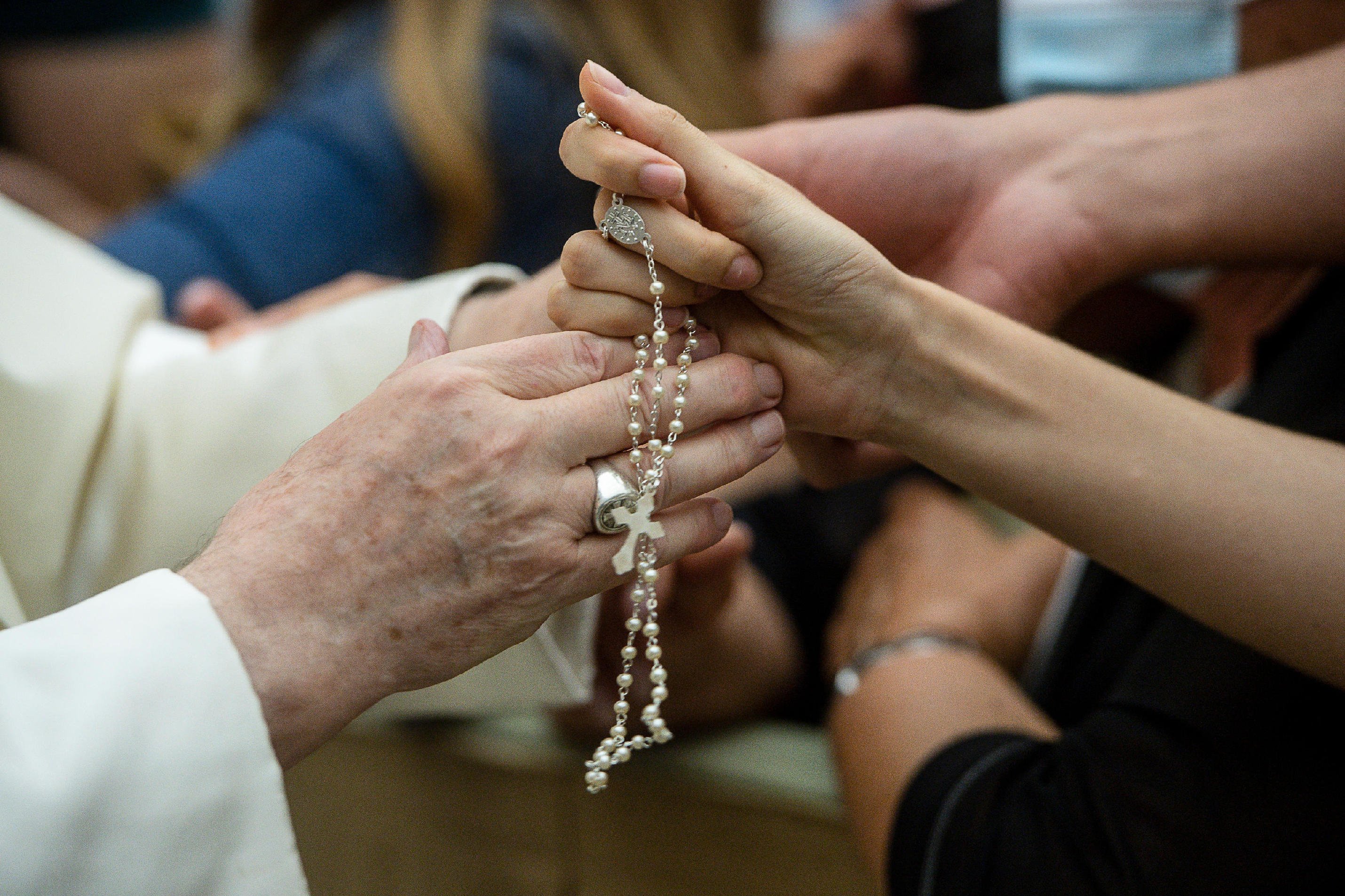 Pope Francis greets a person with a rosary during his general audience in the Vatican's Paul VI hall Aug. 18, 2021. The pope continued his series of talks on St. Paul's Letter to the Galatians. The pope said the law was meant to teach the path toward true