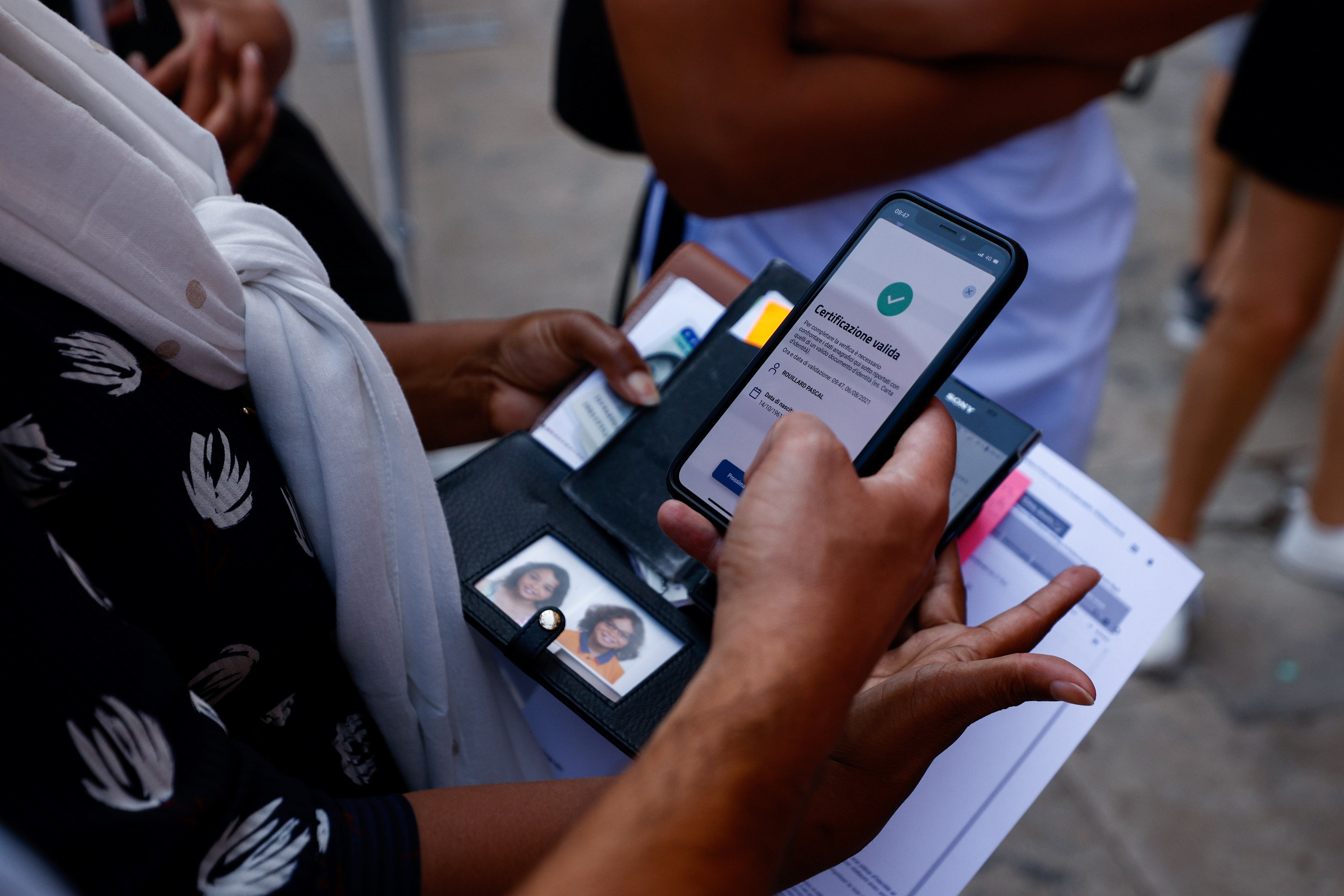 A woman has her Green Pass, signifying vaccination against COVID-19 or a negative test taken within 48 hours, checked before entering the Vatican Museums at the Vatican in this Aug. 6, 2021, file photo. Beginning Oct. 1 the Vatican will require proof of v