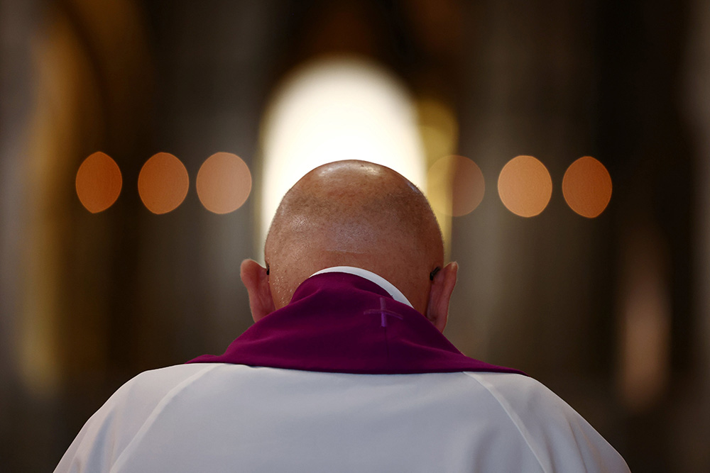 A priest prays inside Sacred Heart Basilica in Paris Oct. 6, 2021. A recent report on clergy sexual abuse in the Catholic Church in France shows there have been 3,000 abusers since the 1950s. (CNS/Reuters/Sarah Meyssonnier)