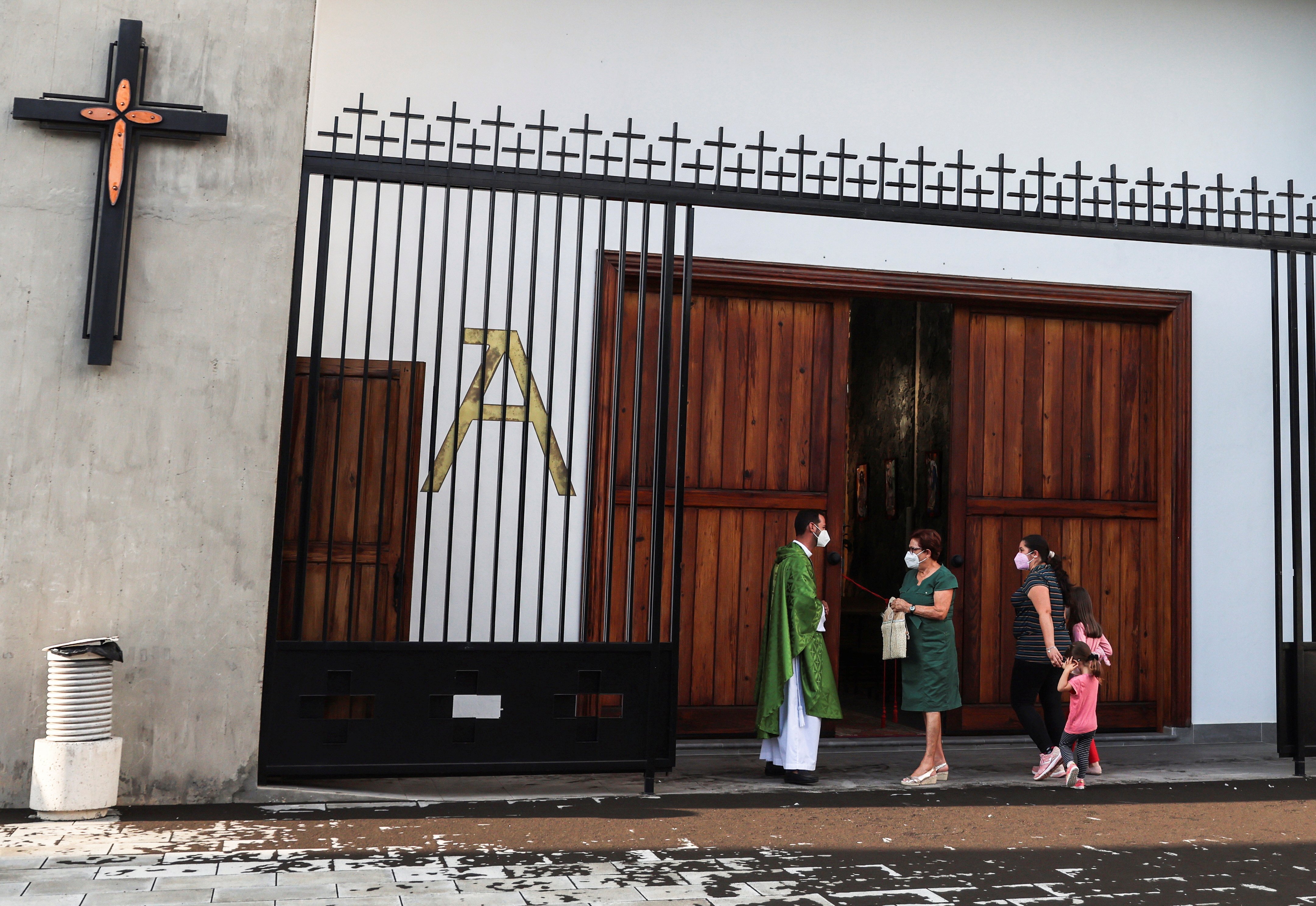 A priest talks with parishioners before celebrating Mass in the Church of San Isidoro in La Palma, Spain, Sept. 25, 2021. (CNS photo/Nacho Doce, Reuters)