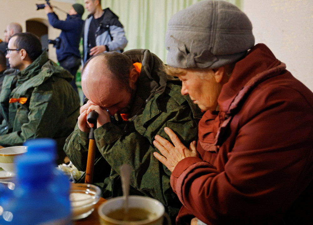 A serviceman from the Russian-controlled Donetsk region of Ukraine sits with his mother in Amvrosiivka, Ukraine, Nov. 6, 2022, following his release in a recent prisoner exchange.