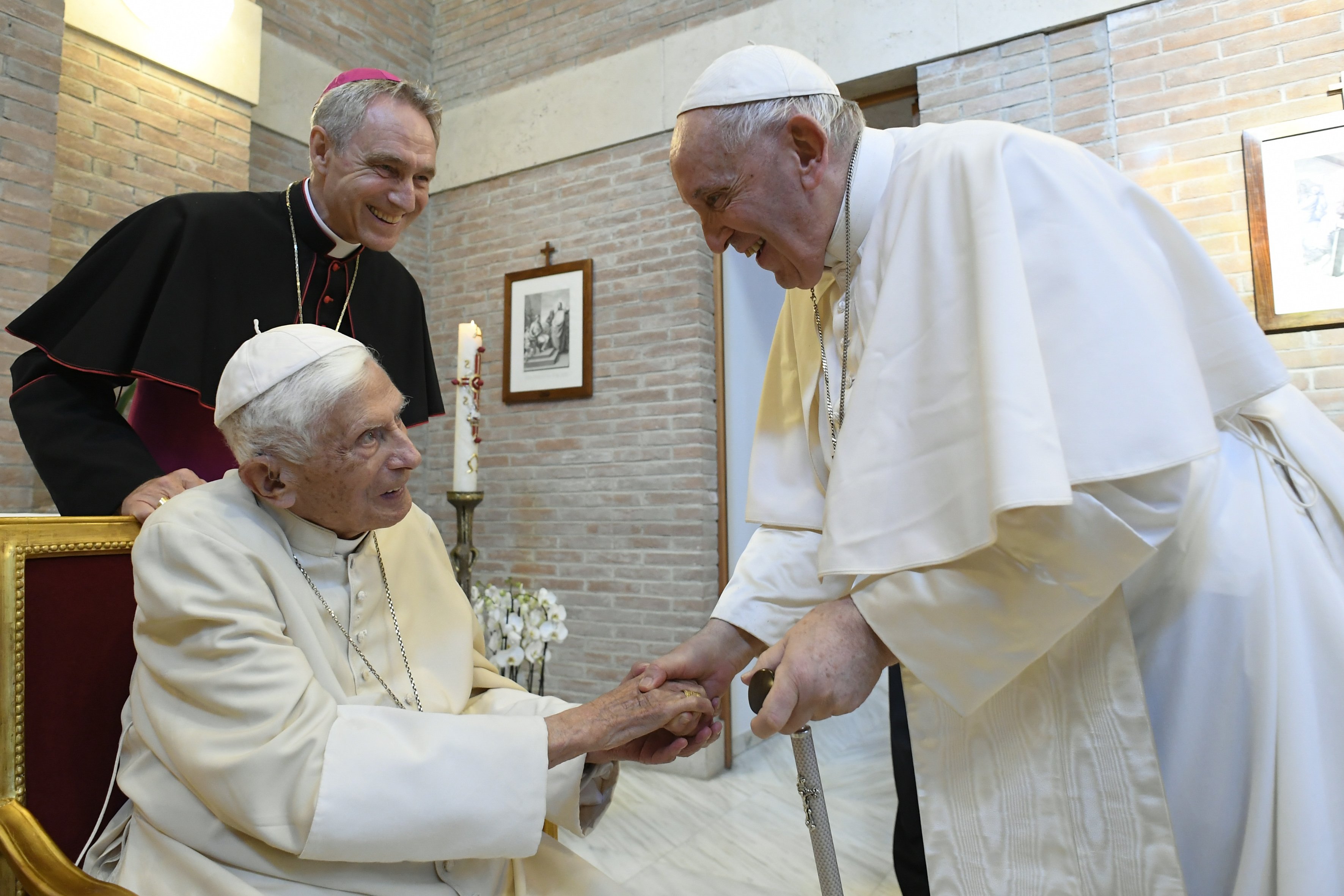 Pope Francis greets retired Pope Benedict XVI at the Mater Ecclesiae monastery after a consistory for the creation of 20 new cardinals in St. Peter's Basilica at the Vatican Aug. 27, 2022. Looking on is Archbishop Georg Gänswein, the retired pope's private secretary. (CNS photo/Vatican Media)