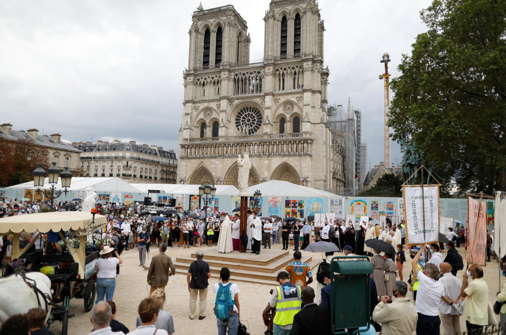 People gather around priests outside Notre Dame Cathedral