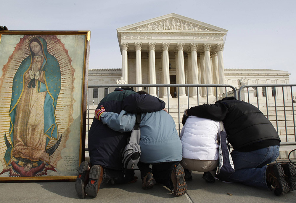 March for Life participants kneel in prayer alongside an image of Our Lady of Guadalupe in front of the Supreme Court building Jan. 24, 2011, in Washington. (CNS/Reuters/Jim Young)