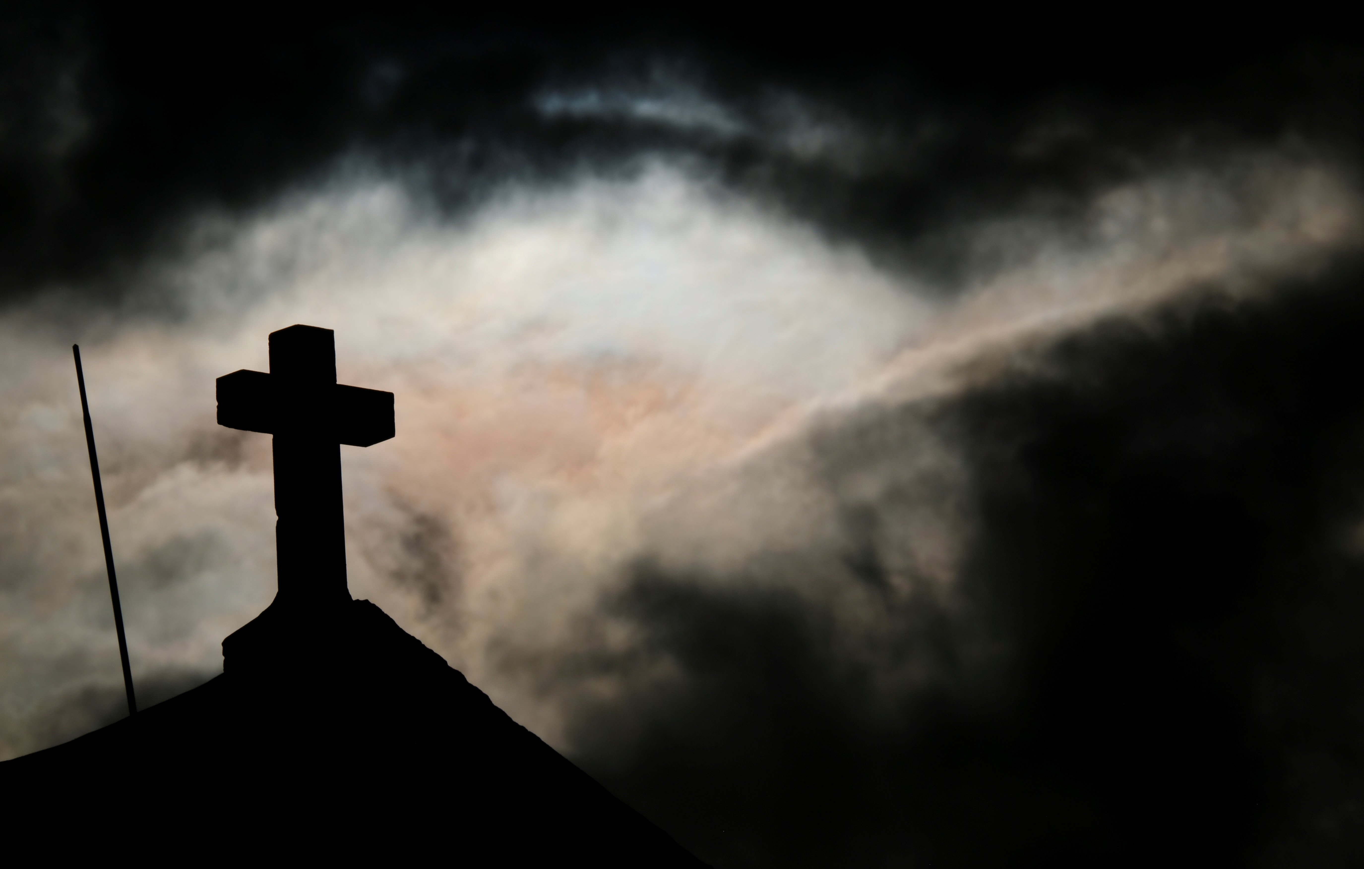 A cross on top of St. Mary Magdalene Chapel, on Dingli Cliffs, is pictured as clouds obscure the sun outside the village of Dingli, Malta, in this Jan. 14, 2022, (CNS photo/Darrin Zammit Lupi, Reuters)