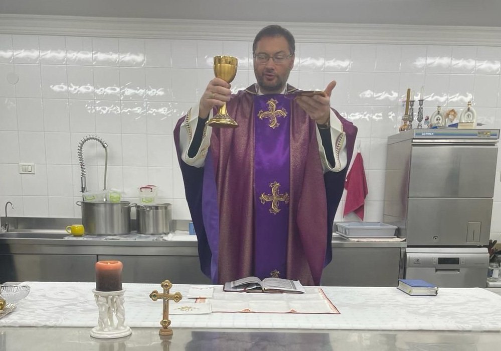 Archbishop Visvaldas Kulbokas, apostolic nuncio to Ukraine, elevates the Eucharist in the kitchen at the apostolic nunciature in Kyiv, Ukraine, in this recent photo. During the war, Archbishop Kulbokas has been celebrating Mass in the kitchen because it's