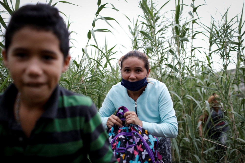 Migrants from Venezuela walk along a trail after crossing the Rio Grande in Del Rio, Texas, May 23, 2022. (CNS photo/Marco Bello, Reuters)