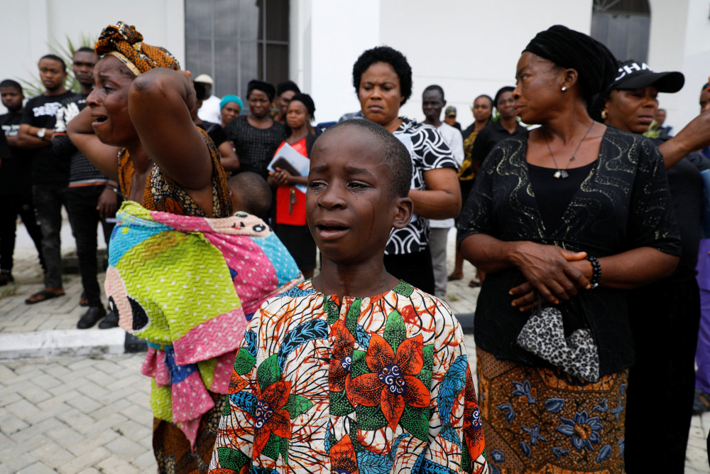 A woman and child cry following a funeral Mass in the parish hall of St. Francis Xavier Church in Owo, Nigeria, June 17. The Mass was for some of the 40 victims killed in a June 5 attack by gunmen during Mass at the church. (CNS/Reuters/Temilade Adelaja)