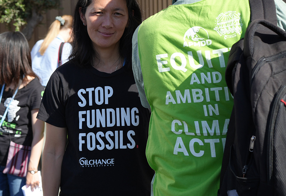 A protester wears a T-shirt with the message "Stop funding fossils" during a demonstration at the COP27 climate summit Nov. 9, 2022, in Sharm el-Sheikh, Egypt. Over 50 activists of all ages and backgrounds took over the so-called "Blue Zone" — the central area of the conference center in Sharm el-Sheikh — to chant, "Stop funding fossil fuels! Stop funding death!" (EarthBeat photo/Doreen Ajiambo)