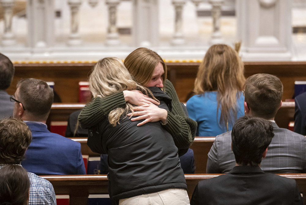 Friends and supporters console each other during a memorial service for Brian Fraser at St. Paul on the Lake Catholic Church in Grosse Pointe Farms, Michigan, Feb. 14. Fraser was identified as one of the students slain during a mass shooting on Michigan State University's campus the night before. (Detroit News via AP, Pool/David Guralnick)