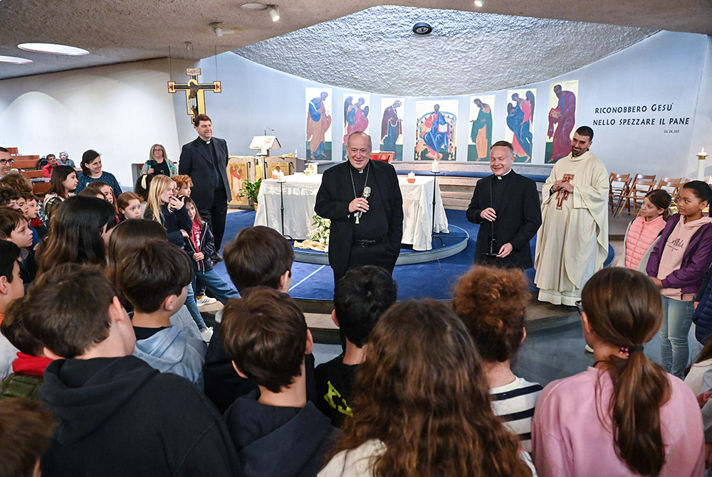 Cardinal Robert W. McElroy of San Diego speaks with young members of the parish of St. Frumentius, his titular church in Rome, before formally taking possession of the church and celebrating Mass there April 23. (CNS/Chris Warde-Jones)