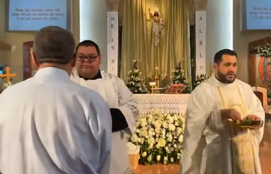 Communion is distributed during an Easter Mass April 9 at St. Emydius Church in Los Angeles County, California. The parish of 20,000 families offers 10 Sunday Masses, 9 of which are celebrated in Spanish. (NCR Photo/YouTube/St. Emydius Church)