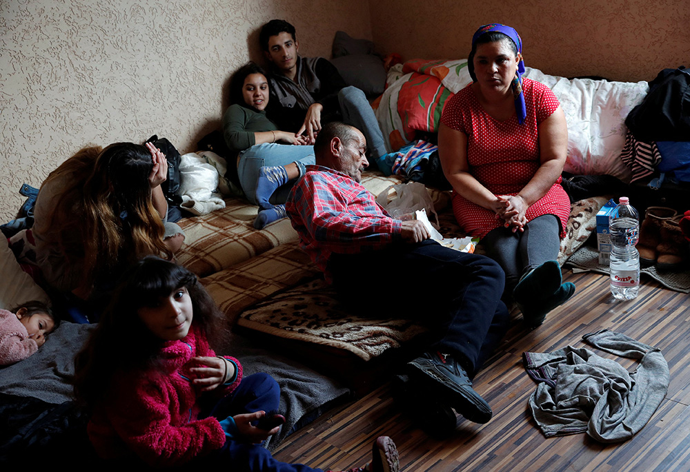 People who fled Russia's invasion of Ukraine rest at a local resident's home, March 2, 2022, in Tiszabecs, Hungary. (CNS/Reuters/Bernadett Szabo)