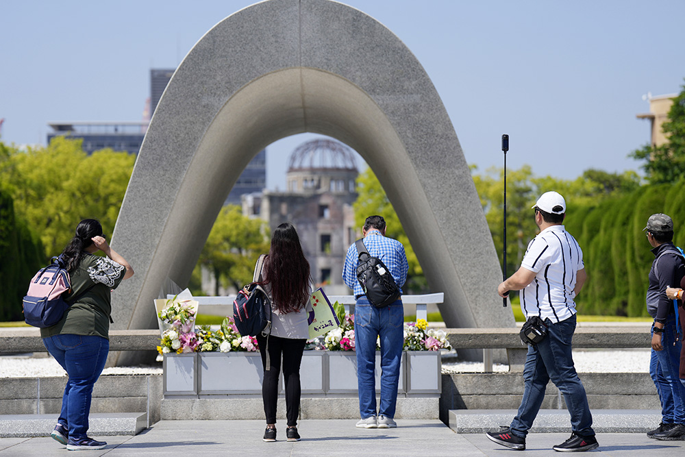 Visitors pray before flowers placed at the Hiroshima Peace Memorial Park in Hiroshima, Japan, on May 17, ahead of the G-7 summit in the city. (AP/Hiro Komae)