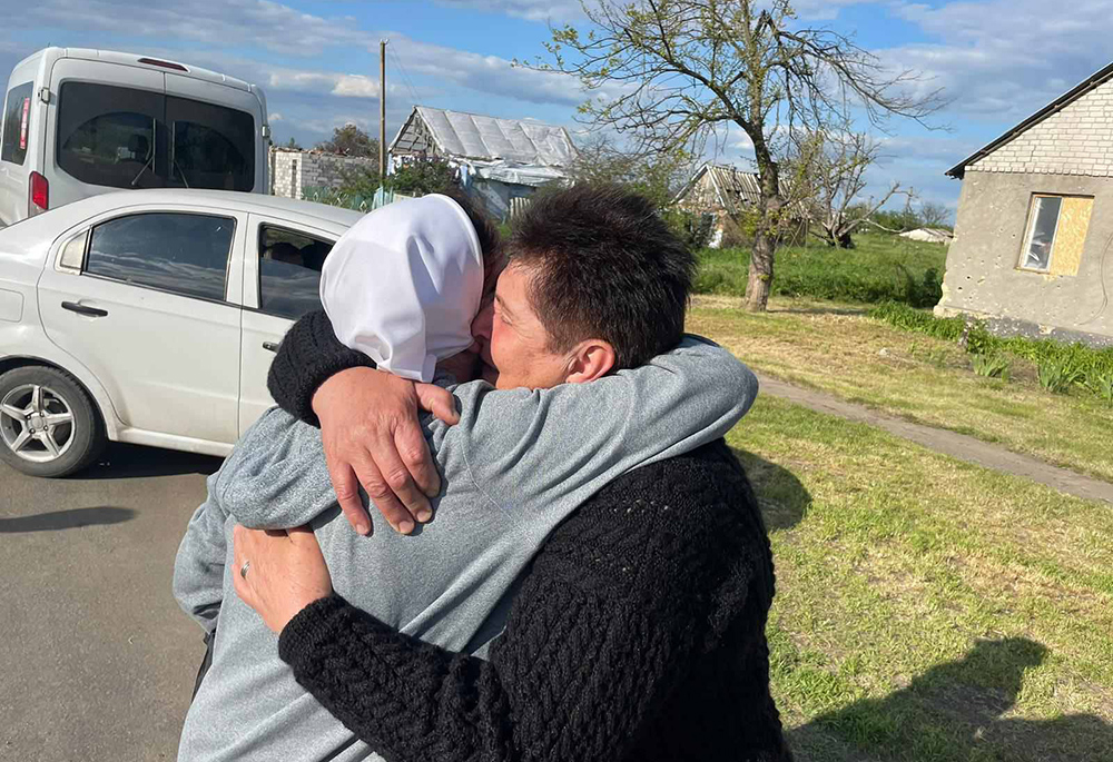 During a recent humanitarian mission to war-torn eastern Ukraine, Sr. Lydia Tomchuk hugs a villager near Mykolaiv. (Courtesy of Sr. Lydia Timkova)