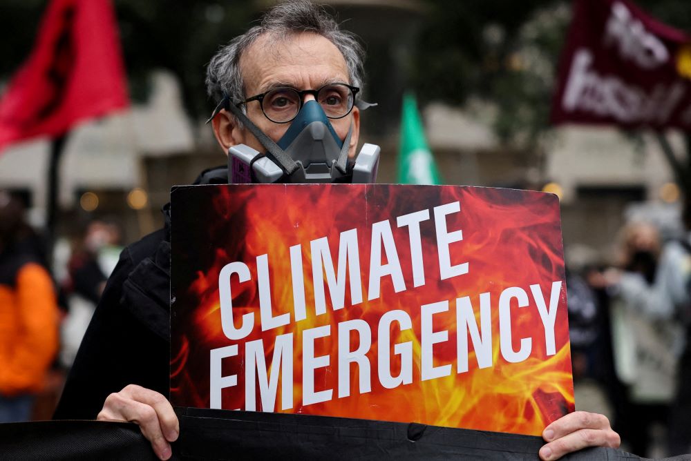 A climate activist wearing a protective mask protests June 8, 2023, while smoke and haze caused by wildfires in Canada pass through New York City. (OSV News photo/Amr Alfiky, Reuters)