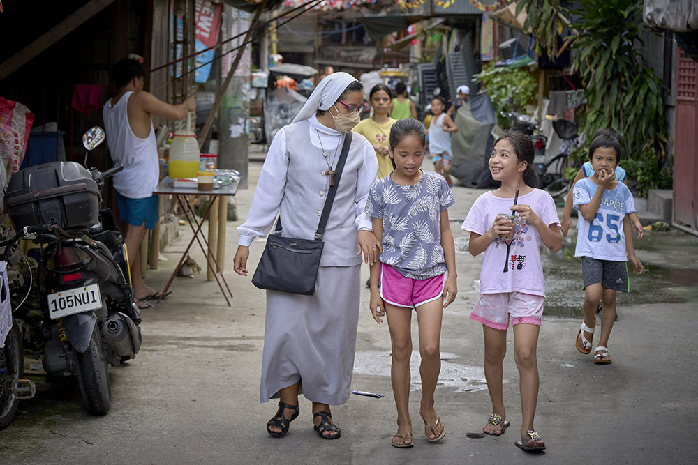 Sr. Mitzy Pérez, a member of the Missionary Sisters Servants of the Word from San Luis Potosi, Mexico, walks in a poor neighborhood of Kalookan, Philippines, Oct. 17, 2022. The diocese has established a mission station there to extend the outreach of the church to poor neighborhoods unreached by traditional parish structures. (CNS/Paul Jeffrey)