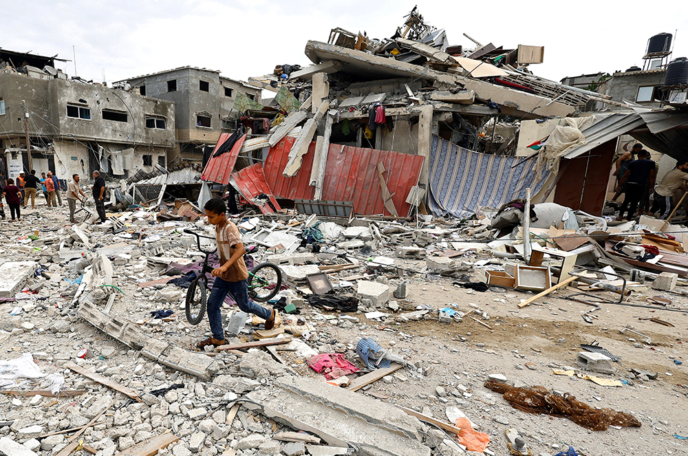 A child walks at the site of an Israeli air strike on a house in Khan Younis in the southern Gaza Strip Oct. 27 as the conflict between Israel and Palestinian Islamist group Hamas continues. (OSV News/Reuters/Mohammed Salem)