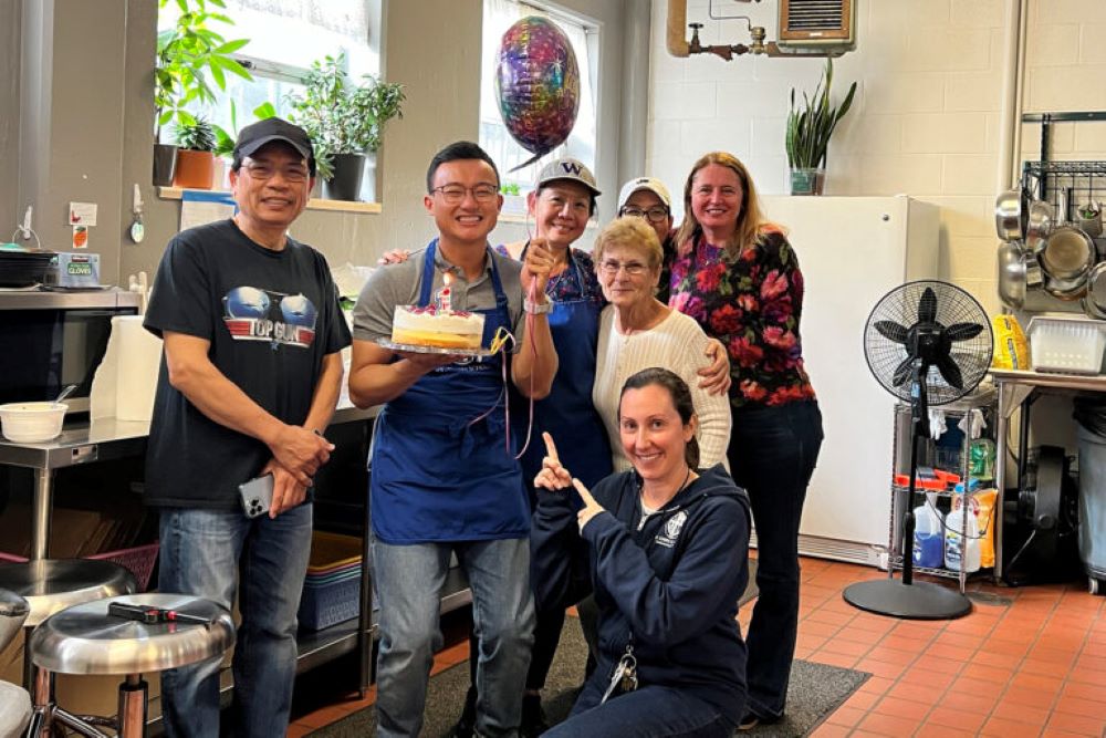  Tuan Anh Nguyen holds a cake as he celebrates his first anniversary at an apostolate in Seattle. He is one of three men exploring calls to the priesthood who live at a Jesuit discernment house. (RNS/Courtesy photo)