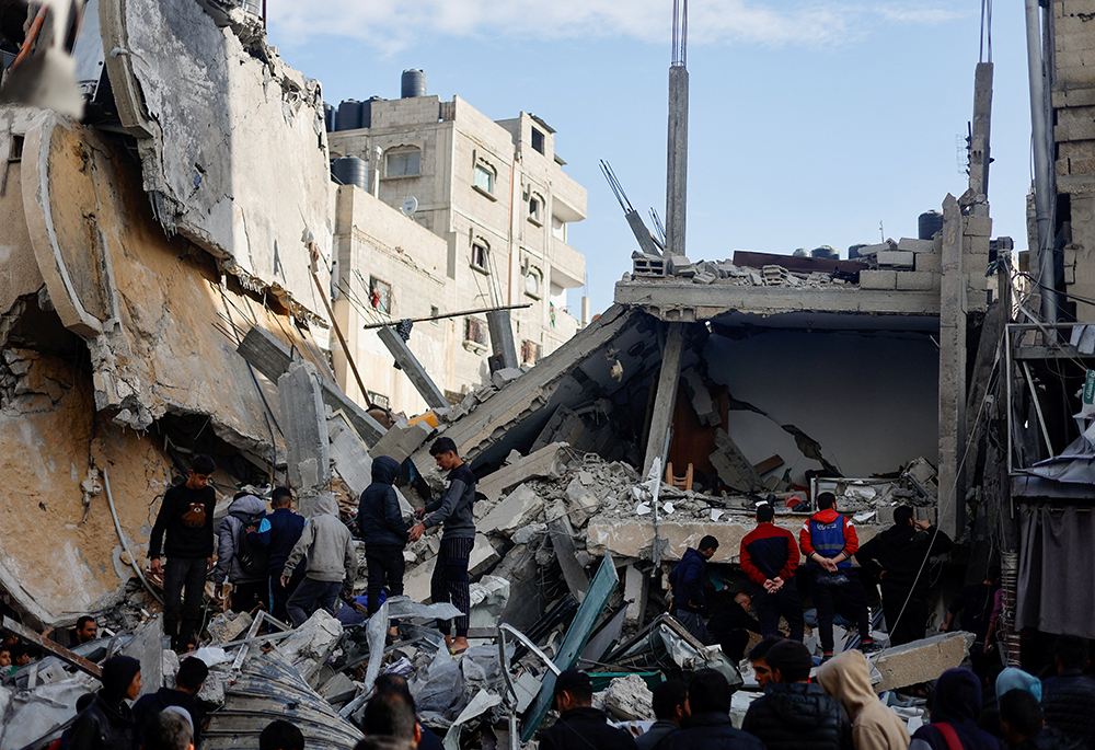 Palestinians gather March 4 at buildings in Rafah, in the southern Gaza Strip, that were destroyed by an Israeli airstrike amid the ongoing conflict between Israel and Hamas. (OSV News/Mohammed Salem)