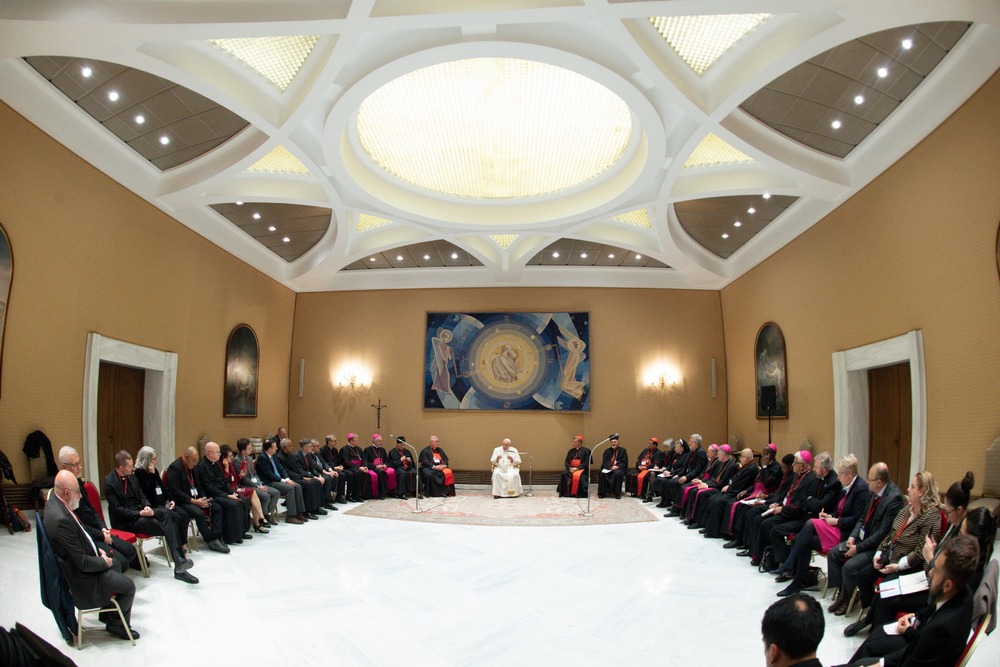 Pope Francis, seated, presides over large meeting