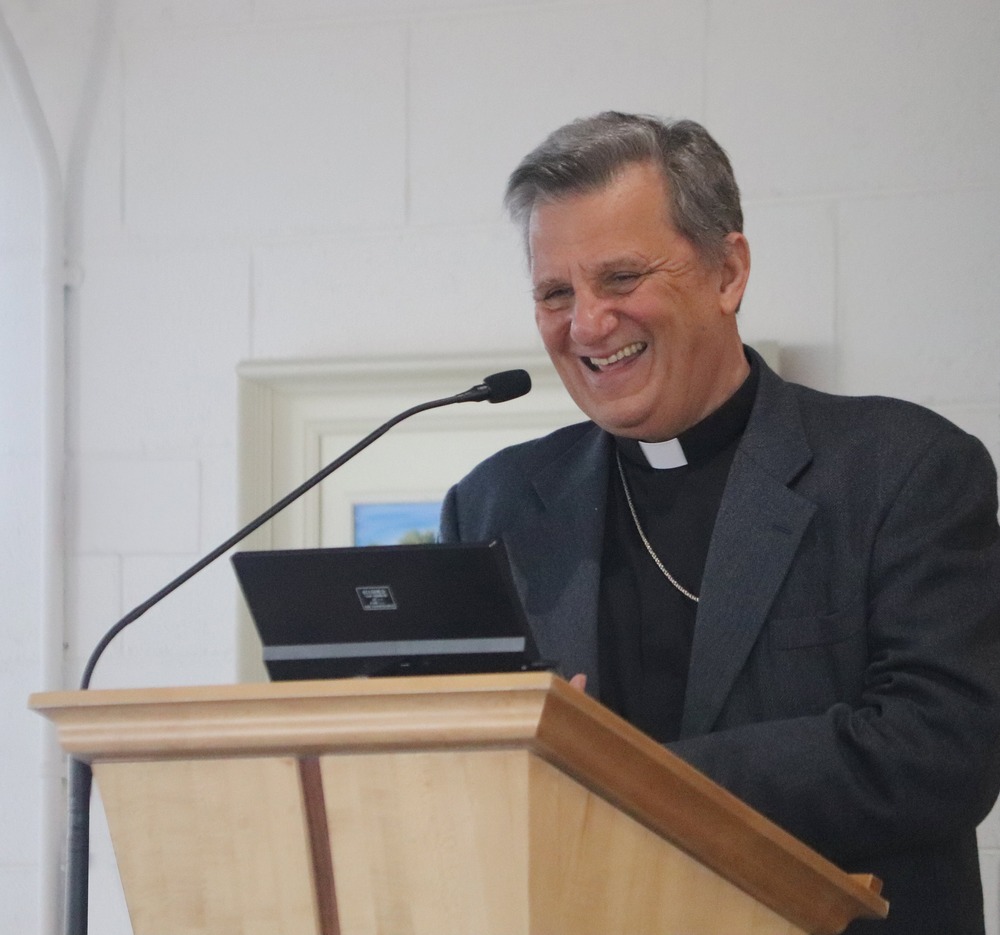 Cardinal Grech stands at lectern.