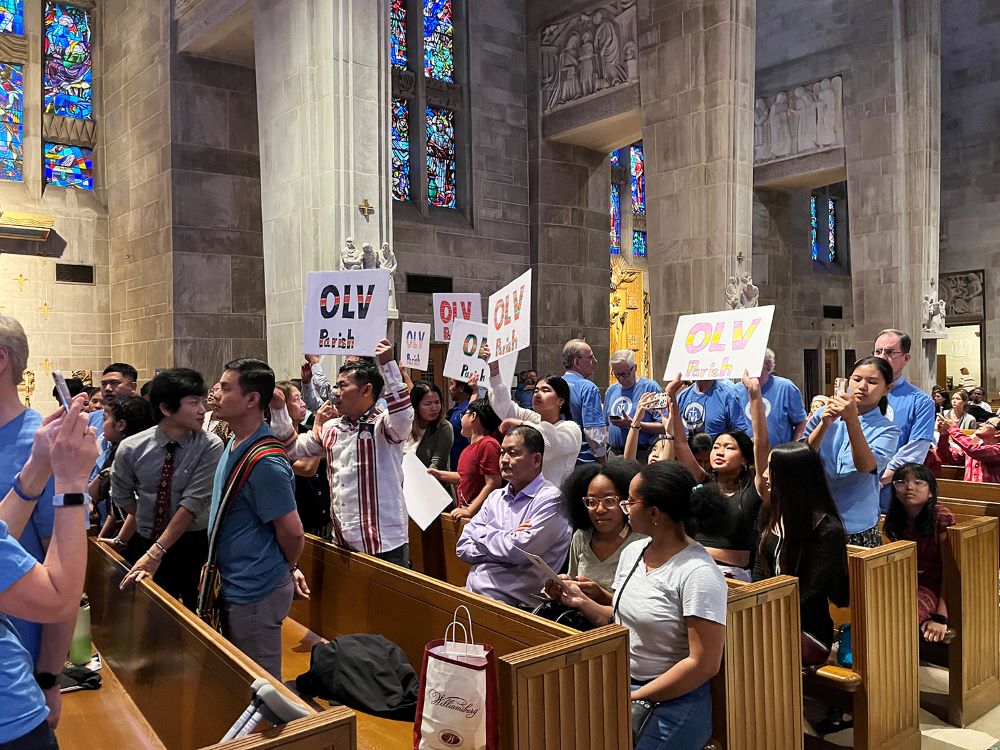 Community attendees wave flags during a community forum at Cathedral of Mary Our Queen in the Archdiocese of Baltimore April 30.