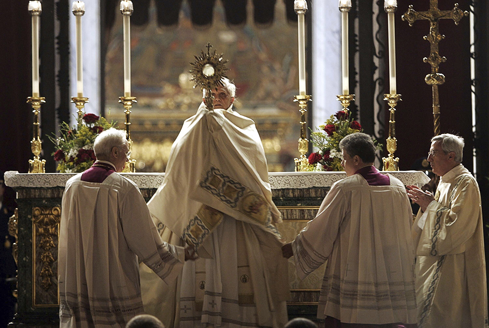 Pope Benedict XVI hoists a monstrance containing a Holy Host during a Corpus Domini celebration outside St. Mary Major Basilica to mark the feast of the Body and Blood of Christ, in Rome May 26, 2005. (AP/Domenico Stinellis, File)