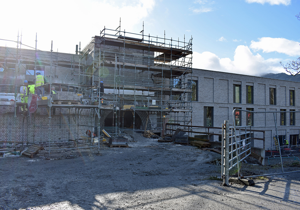 Workmen and scaffolding are still visible near the arched monastic entrance to the new monastery at Kylemore Abbey in the final weeks of construction. (Julie A. Ferraro)