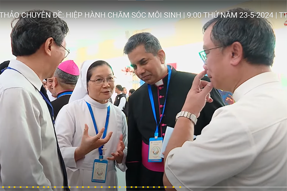 Msgr. Indunil Janakaratne Kodithuwakku Kankanamalage (in black) talks with participants at the gathering on May 23 in Ho Chi Minh City. (Screenshot/Joachim Pham/hdgmvietnam.com)