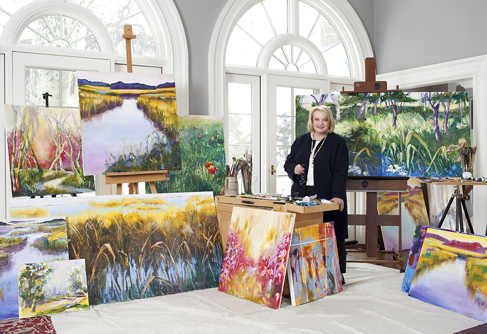 Janet Hennessey Dilenschneider poses with some of her paintings. The artist currently has an exhibit at the gallery of the Sheen Center for Thought and Culture in Manhattan, entitled "Come to the Light." (Courtesy of Sheen Center for Thought and Culture)