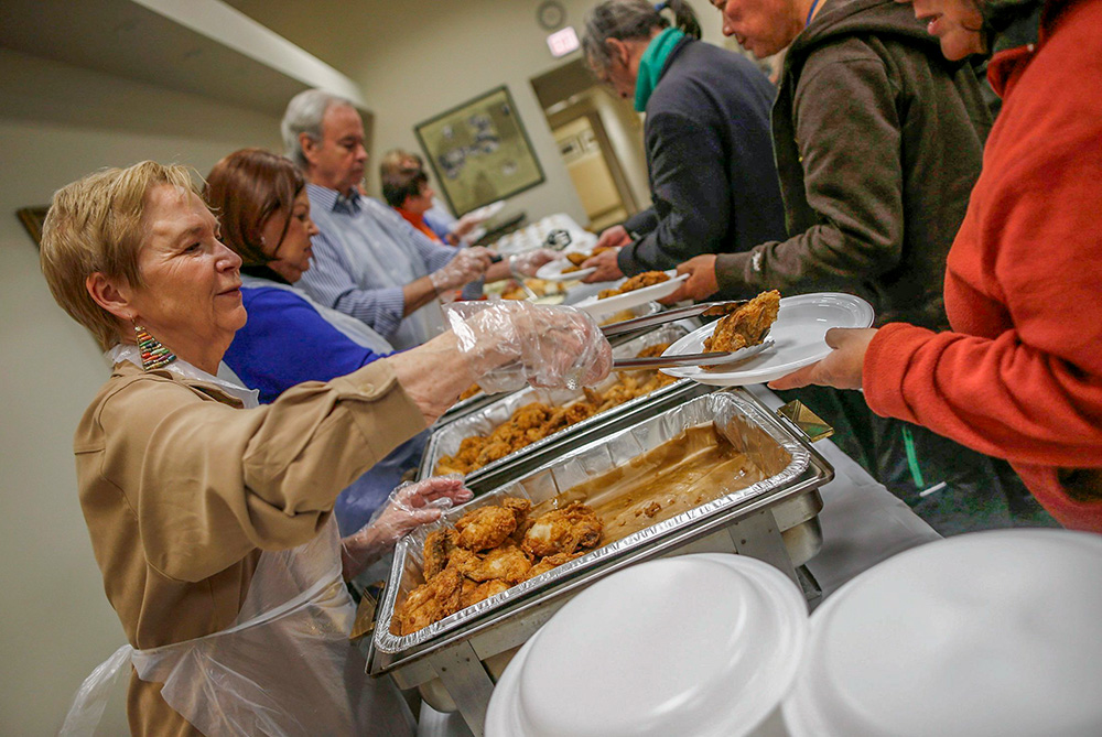 In a 2013 file photo, volunteers serve people during a free dinner provided by the Emergency Assistance Department of Chicago Catholic Charities. (CNS/Reuters/Jim Young)