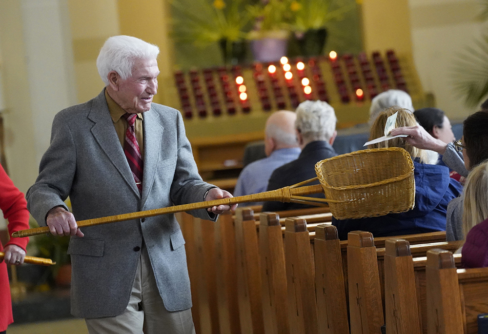 An usher uses a collection basket during the offertory portion of the Mass in this file photo from April 16, 2023. (OSV News/Gregory A. Shemitz)