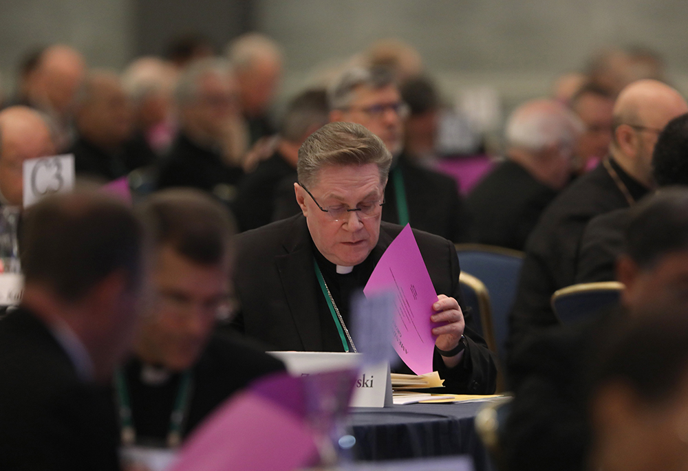 Auxiliary Bishop Andrzej Zglejszewski of Rockville Centre, New York, looks over paperwork during a Nov. 15, 2023, session of the fall general assembly of the U.S. Conference of Catholic Bishops in Baltimore. At its upcoming spring 2024 meeting, the conference may revamp or scale back the Catholic Campaign for Human Development. (OSV News/Bob Roller)