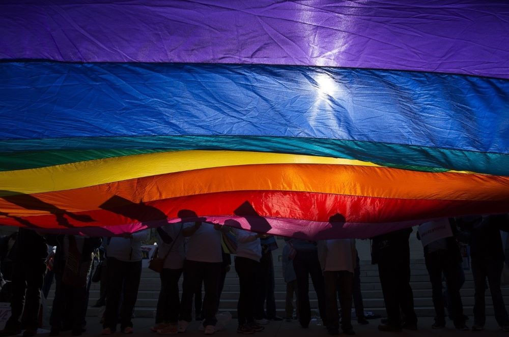 In this 2015 file photo, LGBTQ supporters wave a flag outside the U.S. Supreme Court in Washington. 