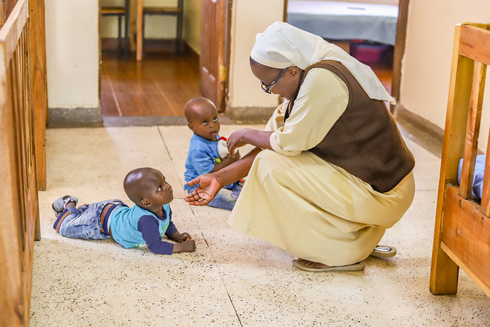 Sr. Judith Auma, a member of the Little Sisters of St. Francis of Assisi, plays with two children on Jan. 17 at St. Josephine Bakhita Babies Home in Busia, a town in western Kenya on the border with Uganda. Religious sisters are taking care of abandoned children, especially those born out of incest. (GSR photo/Doreen Ajiambo)