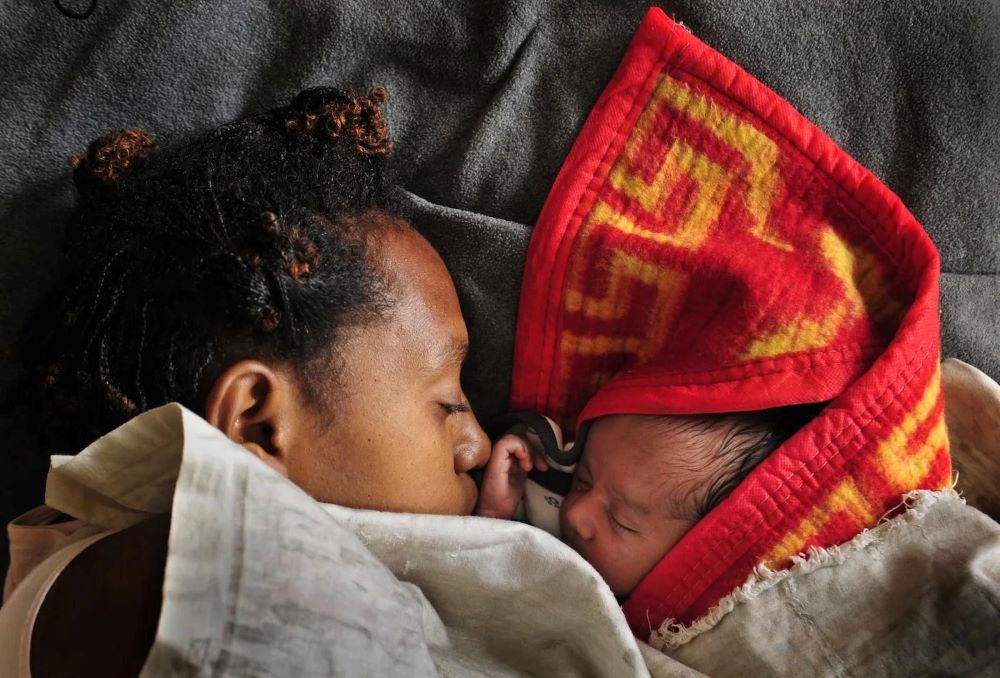 A woman sleeps with her baby in the maternity ward of a hospital in Goroka in the Eastern Highlands Province of Papua New Guinea in 2009. (Grist/Fairfax Media via Getty Images/Jason South)