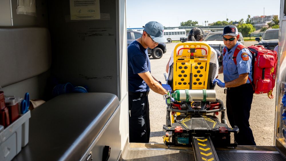 Emergency medical technicians respond to a pregnant woman suffering from dehydration in July 2023 in Eagle Pass, Texas. Grist/Getty Images/Brandon Bell)