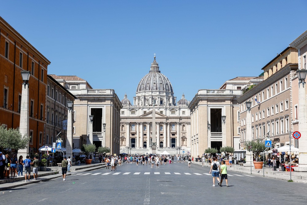 St. Peter's viewed from road lined with buildings. 