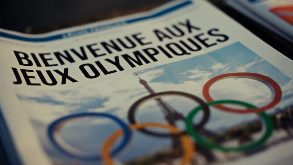 Cover of paper displays graphic of the Olympian rings superimposed over the Eiffel Tower. 