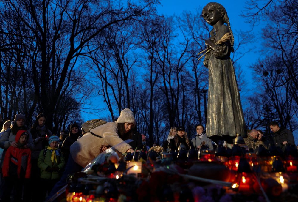 People visit a monument to Holodomor victims in Kyiv, Ukraine, Nov. 25, 2023, during a ceremony commemorating the famine of 1932-33.